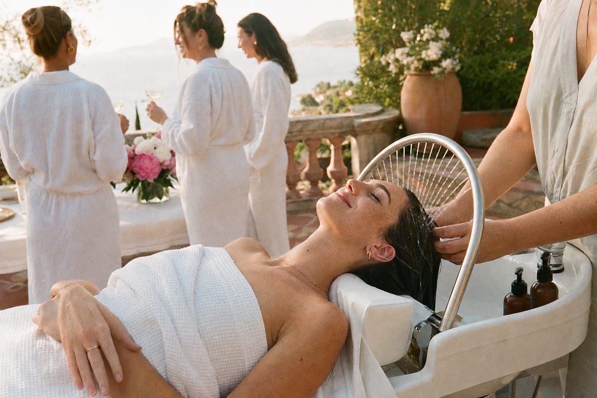 Deux postes de head spa dressés sur une terrasse face à la mer, pivoines et coupes de champagne